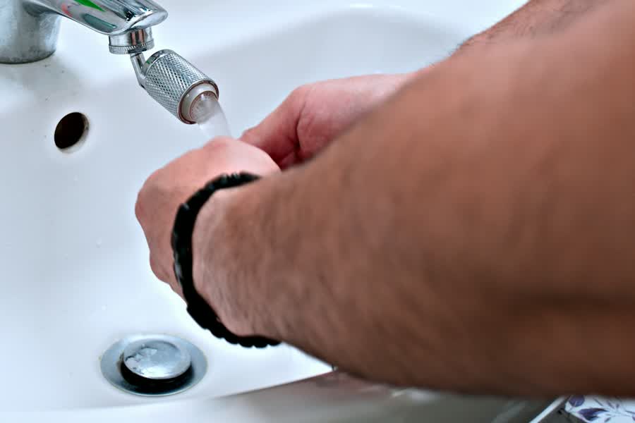 Hand adjusting a bathroom faucet
